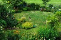 Elevated view of cottage garden and lawn with patterns mown into it. Suffolk, UK