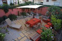 Urban patio garden with sunshade and furniture