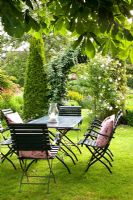 Dining area on lawn in country garden

