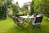 Dining area on lawn in country garden 


