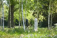 Modern sculpture designed by Mark Humphrey  underneath Betula - Birch trees in meadow at Hatfield House garden, May 2008, UK