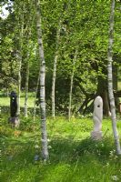 Modern sculptures designed by Mark Humphrey underneath Betula - Birch trees in meadow at Hatfield House garden, May 2008, UK