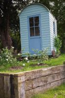 Restored shepherd's hut with raised railway sleeper edging - Northend