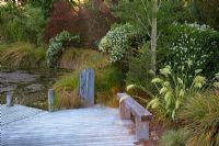 Large pond with wooden jetty, surrounded by flowerbed - Breedenbroek, New Zealand