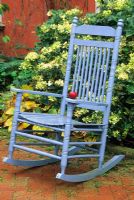 Blue rocking chair with red apple on terrace