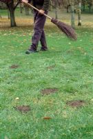 Autumn lawn care - Top dress the lawn by spreading a sandy loam mixture in dollops at 3lb  square metre all over the surface. Brush the dressing lightly into the turf to fill holes and gaps, using the back of a rake or besom broom