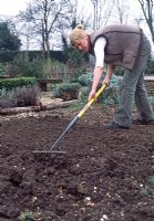 Sowing grass seed over the patch and rake lightly to cover some of the seeds