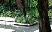 Tropical style garden with island beds in pond.The Tourism Malaysia Garden, Gold medal winner, RHS Chelsea Flower Show 2010 
 