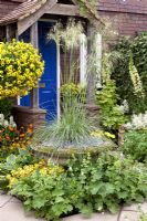 Front garden of cottage with Stipa gigantea in island bed. The Sun Golden Wedding Garden, Silver Gilt Medal Winner, RHS Chelsea Flower Show 2010 
 