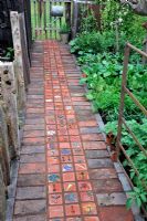 Decorative brick path in kitchen garden with hand made terracotta tiles - RHS Malvern Spring Gardening Show