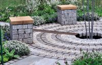 Gabion seats in circular garden with cobble stone and pebble circles - RHS Malvern Spring Gardeneing Show