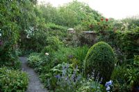 Pathway through mixed early summer borders in walled garden - Old Buckhurst, Kent