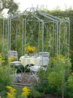 Metal pavilion with seating area, planting includes Solidago, Thunbergia and Spartina 