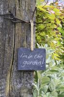 Slate sign on garden gate, reading 'I'm in the garden' 