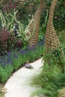 Interwoven willow structures adding architectural interest to borders in wildlife garden. 'It's Only Natural' - Silver Gilt Medal Winner - RHS Hampton Court Flower Show 2010 
 