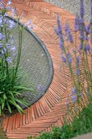 Herringbone terracotta tiles and water feature. 'The Garden Lounge' - Silver Gilt Medal Winner - RHS Hampton Court Flower Show 2010 