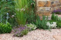 Herbs, grasses and perennials growing through gravel. 'The Fire Pit Garden' - Silver Medal Winner - RHS Hampton Court Flower Show 2010 