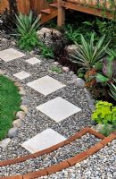Slab stepping stones in gravel path, edged with large pebbles - RHS Tatton Park Flower show 2010