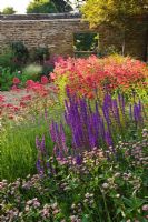 Summer borders of perennials and Centranthus ruber in gravel garden. Rickyard Barn Garden, Northamptonshire
