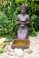 Kneeling Thai Statue at Meadow Ave, Southport, Lancashire. The garden opens for The National Gardens Scheme