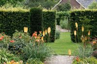 Hemerocallis 'Bold Tiger', Kniphofia 'Tawny King' and Rosa 'Sahara' in Dutch garden and tearoom - De Tuinen in Demen