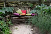 Rustic bench with colourful cushions in Dutch garden and tearoom - De Tuinen in Demen