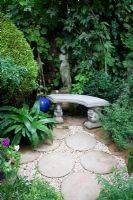 Statue and bench with round paving stones. Nina and Fred Preston's garden
 