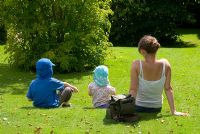 Mother and children relaxing in the sun in a garden