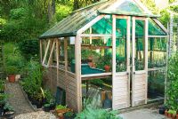 Wooden greenhouse with tomatoes inside, beside vegetable patch - Mill House, Netherbury, Dorset