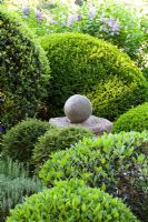 Clipped shrubs and stone finial - La Louve garden, Provence, France