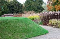 A grass mound and gravel path border in the new area of perennials and grasses, designed by Piet Oudolf - Trentham Gardens, Staffordshire, October