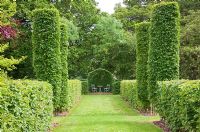 Allee with Carpinus betulus - Hornbeam hedges and four Hornbeam pillars leads to Hornbeam arbour with seating. High Canfold Farm, Surrey 
 