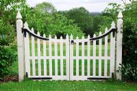 White wooden decorative gate leads through to the orchard. . High Canfold Farm, Surrey 