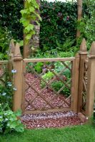Wooden gate and border of Alchemilla and Nigella beyond. The Mod-ieval Garden - RHS Tatton Park 2010
