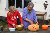 Leonie Woolhouse carving a pumpkin for Halloween with her grandaughter, Tabitha - The Old Sun House, Wymondham, Norfolk, NGS 