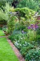 Late spring border with Allium 'Purple Sensation' and brick mowing strip. Dawn End Lodge NGS, May 