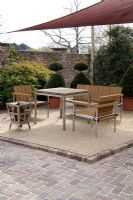 Log fire and wooden furniture on patio with canvas canopy - Appeltern garden, Holland 