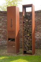 Rusted metal log burning patio heater and wood storage - Appeltern garden, Holland 