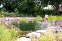 Family swimming in a natural swimming pool
