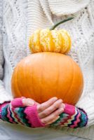 Woman holding pumpkin and squash