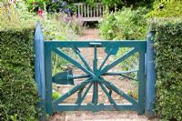 Painted blue garden gate made from old gardening tools