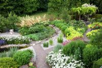 Overview of pond and planting of Alchemilla mollis, Rosa 'Venice' and Achillea 