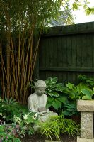 Small urban garden with Buddha statue, bamboo, Hosta, Dicentra and Hakonechloa - NGS garden, Foster Road, Peterborough, Cambridgeshire