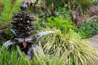 Metal sculpted water fountain by Humphrey Bowden alongisde landscaped pond. Park Terrace, Tillington