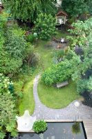 Urban garden viewed from above, showing resin water feature, rectangular pond and curved slate path under metal arch. Yulia Badian garden, London, UK