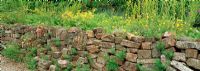 A retaining dry stone wall made from recycled bricks