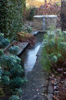 Rill with a well and trickle of water at the end. Formerly a path. The Old Malthouse
 