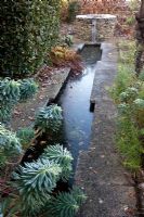 Rill with a well and trickle of water at the end. Formerly a path. The Old Malthouse 