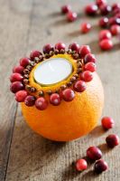 Making an orange, cranberry and clove tealight decoration - STEP 8. The orange with a ring of cloves and a ring of cranberries