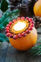 Making an orange, cranberry and clove tealight decoration - Finished decoration with a lit tealight.